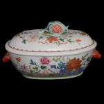 Sopeira de formato oblongo de porcelana Companhia das Índias, decorada com os esmaltes da Famile Rosa. Corpo oblongo de bojo abaulado, decorado com representações florais. Pegas laterais em feitio de cabeças de lebre, e pega da tampa em feitio de romã entre folhagens. China. Qing (1644-1912). Reinado Qianlong (1736-1795). 20 x 37 x 22 cm.