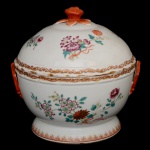 Sopeira de porcelana Companhia das Índias, decorada com os esmaltes da Famile Rose. Corpo em formato esférico decorado com motivos florais. Pegas modeladas, sendo a da tampa no feitio de fruto sobre folhagens rematadas em esmaltagem rouge de fer. China. Dinastia Qing (1644-1917). Reinado Qianlong (1736-1785). 27 x 26 x 24 cm.