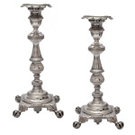 Par de castiçais em prata brasileira repuxada e cinzelada, ornados com frisos geométricos. Hastes construídas em segmentos de balaústre, anelados e carreteis, encimadas por bobeches com bordas dentadas. Bases quadrangulares recortadas, apoiadas em pés de garra e bola. Contrastes 10 Dinheiros do Rio de Janeiro e marcas do prateiro F.S. não identificado, porém do séc. XIX. Medida 23 x 11 cm. Peso 952 gramas..