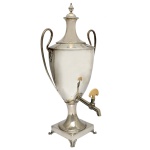Refresqueira em prata inglesa. Apresenta copo liso no formato de taça e alças recurvas. Base quadrangular. Período George III. Contraste da cidade de Londres de 1783 e marcas do prateiro John King. 55 cm.  Peso aprox. 2k 566 gramas.
