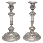 Par de castiçais de prata portuguesa repuxada e cinzelada, ornamentados por frisos florais. Hastes construídas em segmentos de balaústre, encimadas por bobeches abauladas. Bases circulares almofadadas. Contrastes do Porto P Coroa atribuíveis a Manuel da Silva, usados c.1853 e marcas do prateiro Luís Antônio Rodrigues de Araújo, ativo entre 1843-1853. (Moitinho, P-41 à p.194 e P-428 à p.266). 24 cm. 814 gramas.