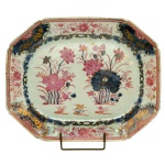 Travessa oblonga e de cantos chanfrados, em porcelana Companhia das Índias, decorada nos esmaltes da Família Rosa. Fundo branco decorado em tons de azul por composição floral ao centro, e moldurado por guirlanda florida. 37 x 29.5 cm. China. Dinastia Qing (1644-1911). Reinado Qianlong (1736-1795).