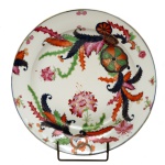Medalhão em porcelana Companhia das Índias, apresentando decoração nos esmaltes da Família Rosa, conhecida como Folha de Chá. China. Dinastia Qing (1644-1911). Reinado Jiaqing (1796-1820). 30 cm.
