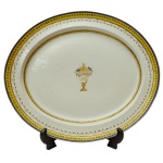 CONDE DO RIO PARDO (Porto, 1790 - Rio de Janeiro, 1849)  Rara travessa de porcelana Companhia das Índias pertencente ao Serviço do Conde do Rio Pardo (Tomas Joaquim Pereira Valente). Borda com friso amarelo decorada com círculos de cor azul repetitivos. Centro com ramo de flores sobre monigrama entrelaçado. China. Dinastia Qing (1644-1911). Séc. XIX. 44 x 38 cm. Exemplar do mesmo serviço reproduzido na pág. 203 do livro "As Companhias das Índias e a Porcelana Chinesa de Encomenda" de Jose Roberto Teixeira Leite.