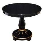 Mesa de apresentação em laca negra, ornamentada por discretos frisos lisos e dourados. Tampo circular apoiado em coluna torneada e anelada. Base esparramada com pés recortados. 73 x 85 cm. Pequenas marcas de uso.