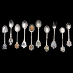 Conjunto de 10 colheres de metal prateado com decoração e materiais variados. 12.5 cm (maior). 11 cm (menor).