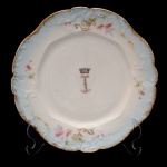 BARÃO DE IBIROCAI - Prato em porcelana francesa de Limoges, pertencente ao Primeiro e único Serviço do Barão de Ibirocaí (Luis de Freitas Vale). Borda recortada na cor azul celeste degrade com arremates em ouro. Flores em policromia e arabescos dourados. Monograma "I" Coroado. França. Manufatura "Barney, Rigoni e Langle". 24 cm. Peça do mesmo serviço reproduzida na pág. 265 do Livro Louça da Aristocracia no Brasil, de Jenny Dreyfus.