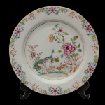 SERVIÇO DOS PAVÕES  Prato fundo de formato circular em porcelana Companhia das Índias, pertencente ao Serviço dos Pavões. Apresenta decoração nos esmaltes da Família Rosa, tendo no centro casal de pavões entre peônias e ramos, circundados por guirlandas floridas. China. Dinastia Qing (1644-1917). Reinado Qianlong (1736-1785). 22 cm. Peça do mesmo serviço reproduzida na pág. 97 do Livro "Louça da Aristocracia no Brasil", por Jenny Dreyfeus.