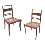 Par de cadeiras brasileiras estilo Regency em madeira lustrada. Encostos vazados e entalhados construídos com montantes retos. Assentos quadrangulares forrados em palhinha. Pernas suavemente curvilíneas.  92 x 48 x 45 cm. Uma cadeira com a palha com defeito.