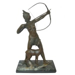 Estatueta em bronze patinado representando original interpretação de Diana Caçadora, deusa romana da lua e da caça, com uma corça aos seus pés. Apresenta-se nesta obra com trajes de plumas, típicos das tribos indígenas das Américas. Base retangular em granito rajado com degrau. 58 x 38 x 12 cm. Base 3,5 x 37 x 19 cm. Arco quebrado e base com bicados.