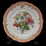 Prato circular de porcelana francesa. Borda ondulada com faixa na cor salmão e detalhes em ouro. Iniciais entrelaçadas em reserva. Centro com decoração de flores e folagens. No verso marca da manufatura CH. Pillivuyt & Cie  Paris. Exp. 1867. Medalle Dor. 22 cm.