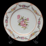 Prato raso de porcelana Companhia das Índias apresentando decoração nos esmaltes da Família Rosa. Superficie branca com borda decorada com guirlandas florais e centro com buquet de flores. China. Dinastia Qing. Séc. XIX. 22 cm.