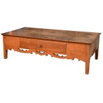 Mesa baixa em madeira clara com tampo retangular liso, apoiado em caixa reta apresentando gavetão à frente. Saia recortada e vazada. Pernas retas de secção quadrangular. Provavelmente Séc. XIX. 50 x 170 x 71 cm. Apresenta tampo necessitando de restauro.