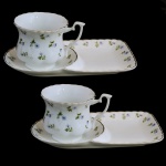 Conjunto de 2 xícaras com presentoir para petiscos de porcelana italiana. Decoração com pequenas flores sobre fundo branco. No fundo as inscrições, Le Gourmet  Italy. 7 x 11 cm xícara). 20 x 13 cm (pires). Este lote encontra-se em Belo Horizonte, MG, e só estará disponível em nossa loja a partir do dia 13 de Outubro.