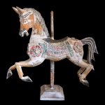 Antigo cavalo de carrossel em madeira policromada. Apresenta-se galopando de boca aberta, decorado por largos florões esculpidos no peito e nas laterais. Suporte com haste vertical apoiada em base quadrangular almofadada. 47 x 51 x 12 cm. Este lote encontra-se em Belo Horizonte, MG, e só estará disponível em nossa loja a partir do dia 13 de Outubro.