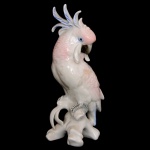 Estatueta em porcelana alemã policromada representando cacatua sobre tronco. No fundo marca da manufatura EPNS. 19 cm. Este lote encontra-se em Belo Horizonte, MG, e só estará disponível em nossa loja a partir do dia 13 de Outubro.