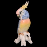 Estatueta em porcelana alemã policromada representando cacatua sobre tronco. No fundo marca da manufatura EPNS. 19 cm. Este lote encontra-se em Belo Horizonte, MG, e só estará disponível em nossa loja a partir do dia 13 de Outubro.