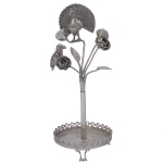 Paliteiro em prata brasileira repuxada e cinzelada. Apresenta pavão e papagaio pousados sobre galhos floridos e inseridos em haste tubular. Base com pequena salva lisa e galeria vazada, apoiada em pés recurvos. 22 x 8 cm / 195 gramas. Este lote encontra-se em Belo Horizonte, MG, e só estará disponível em nossa loja a partir do dia 13 de Outubro.