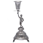 Paliteiro em prata portuguesa repuxada e cinzelada. Apresenta dançarino de pé sobre pedestal, com braço levantado segurando haste com folhas encimada por copo. Base circular abobadada com borda ornada por folhagens. Contraste do Porto Javali 2º Título e marca de prateiro. 21 x 9 cm / 129 gramas.