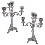 Par de candelabros para 4 velas em prata portuguesa repuxada e cinzelada, profusamente ornamentados em estilo D. João V com frisos, reservas, volutas e folhagens. Hastes construídas com segmentos de balaústre, encimadas por braços recurvos em S, centralizando ponteiras com pequenos castiçais. Bases almofadadas e recortadas de formato triangular, rematadas por pés sobre sapatas. Contrastes do Porto Javali, marcas de prateiros e chancelas da Casa Porto. 50 x 30 x 30 cm. Peso: 5K839 gramas (2872 + 2967 gramas). Este lote encontra-se em Belo Horizonte, MG, e só estará disponível em nossa loja a partir do dia 13 de Outubro.