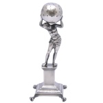 Paliteiro em prata portuguesa repuxada e cinzelada, representando o titã Atlas segurando o globo sobre os ombros. Pedestal no formato de coluna quadrangular lisa, com frisos em degraus, apoiada em base almofadada rematada por pés de garra. Contrastes do Porto do ensaiador Manuel da Silva usado c. 1853 e marca de prateiro não identificado, porém repertoriado e usado na mesma época. (Moitinho P-42 à p.194 e P-437 à p.268). 17 x 5 cm. Peso 217 gramas.