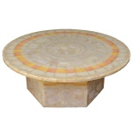 Original mesa construída com placas de resina marmorizada de cor creme. Tampo circular formado por círculos concêntricos, sendo um deles em pedras amarelas e vermelhas alternadas. Larga base de formato hexagonal repetindo friso com veio amarelo e vermelho. Séc. XX. 38 x 110 cm. Lote pertencente ao acervo de tradicional família paulistana de Américo Moreira dos Santos e Anella Mafalda Malzoni. Este lote encontra-se na residência em SP e a retirada devera ser feita a partir do endereço com a orientação da organizadora do leilão.