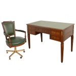 Conjunto de bureau e poltrona, com estrutura em madeira lustrada. Mesa estilo Louis XVI, ornamentada por pequenos adornos florais em bronze ormolu. Tampo retangular com forração em tonalidade oliva, apoiado em caixa reta apresentando gavetão e par de gavetas nas laterais. Pernas retas e filetadas no formato de colunas de secção quadrangular. Cadeira com encosto reto e canelado, ladeado por braços com montantes torneados. Assento arqueado à frente sustentado por base em metal dourado com coluna e penas retas sobre rodinhas. Estofamento tacheado de cor verde. 77  125  60 cm (mesa). 93 x 56 x 55 cm (cadeira). Lote pertencente ao acervo de tradicional família paulistana de Américo Moreira dos Santos e Anella Mafalda Malzoni. Este lote encontra-se na residência em SP e a retirada devera ser feita a partir do endereço com a orientação da organizadora do leilão.