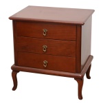 Pequena cômoda lateral em madeira nobre, estilo inglês, com tampo liso bordado por canelados. Caixa reta apresentando três gavetas superpostas. Saia reta com degrau saliente, apoiada em pés recurvos. 64 x 60 x 37 cm. LLote pertencente ao acervo de tradicional família paulistana de Américo Moreira dos Santos e Anella Mafalda Malzoni. Este lote encontra-se na residência em SP e a retirada devera ser feita a partir do endereço com a orientação da organizadora do leilão.