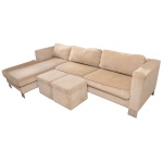 Sofá com chaise para três lugares com estrutura em madeira. Acompanha almofadas soltas e dois pufes. 74 x 290 x 185 cm e 74 x 290 x 90 cm (sofá).  42 x 50 cm (puff). Lote pertencente ao acervo de tradicional família paulistana de Américo Moreira dos Santos e Anella Mafalda Malzoni. Lote pertencente ao acervo de tradicional família paulistana de Américo Moreira dos Santos e Anella Mafalda Malzoni. Este lote encontra-se na residência no Ibirapuera, SP e a retirada devera ser feita a partir do endereço com a orientação da organizadora do leilão.