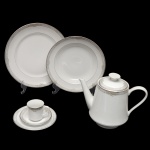 Conjunto de peças para jantar de porcelana nacional. Superfície de fundo branco com delicada decoração com flores amarelas. No fundo marca da manufatura: Porcelana Schmidt, Brasil. Constando de 39 peças, sendo: 18 pratos rasos (25 cm), 10 pratos fundos (23 cm), 1 bule (18 x 23 cm / bico quebrado), 5 xícaras p/ café com pires (6 x 7 cm / pires 10 cm) e 5 pires p/ chá (14 cm). Lote pertencente ao acervo de tradicional família paulistana de Américo Moreira dos Santos e Anella Mafalda Malzoni.