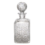 Garrafa para whisky de cristal europeu, translucido e lapidado. Formato quadrangular e tampa na forma de esfera facetada. 25 cm. Lote pertencente ao acervo de tradicional família paulistana de Américo Moreira dos Santos e Anella Mafalda Malzoni.