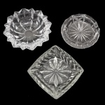 Conjunto de três cinzeiros de cristal europeu translucido e lapidado. 4 x 13 cm; 3 x 11 cm (com leve bicado) e 3 x 12 cm. Lote pertencente ao acervo de tradicional família paulistana de Américo Moreira dos Santos e Anella Mafalda Malzoni.