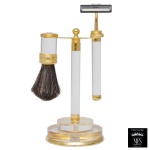 MFS  Design Pierre Murat. Conjunto para toilette na cor branca, com corpo e base dourado. Composto de pincel e barbeador. 18 x 8 cm. Peça nova sem uso. MFS tradicional fabricante de joias de elevado padrão de qualidade, reuniu técnica, talento e beleza artesanal. A experiencia e o pioneirismo no ramo joalheiro permitiram a criação de Produtos Finos para presentes que possuem componentes banhados a ouro 14 Quilates e as cores são resultado do aprimoramento da técnica revestida a fogo e da qualidade MFS. Lote pertencente ao acervo de tradicional família paulistana de Américo Moreira dos Santos e Anella Mafalda Malzoni.