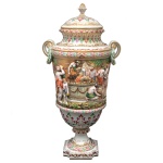 Jarra com tampa no formato de urna, em porcelana italiana policromada, moldada e ornamentada em relevo com numerosos personagens em cena festiva. Bojo levemente cônico, com frisos canelados e folhagens, ladeado por alças em argolas. Tampa abobadada com pega em botão floral. Base circular esparramada sobre peanha quadrangular chanfrada. Sob a base, marca da manufatura de Capodimonte, em Nápoles. 71 x 36 cm. Apresenta restauro antigo no bojo. Lote pertencente ao acervo de tradicional família paulistana de Américo Moreira dos Santos e Anella Mafalda Malzoni.