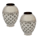 Par de vasos em prata portuguesa repuxada e cinzelada, de formato ovalado, ornamentados por largos florões. Partes superiores lisas encimadas por gargalos curtos realçados por frisos florais. Bases circulares. Contrastes do Porto, provavelmente Javali. 2º Título e marca de prateiro. 2 x 8 cm. bocal 4,5 cm. 348 gramas.  110 gramas. Lote pertencente ao acervo de tradicional família paulistana de Américo Moreira dos Santos e Anella Mafalda Malzoni.