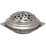 Centro de mesa circular Art Déco com floreira em prata portuguesa lisa, ornamentado a meia altura por larga faixa repuxada e cinzelada com adornos florais e frutas. Bojo e tampa construídos em degraus lisos. Alças laterais retas, no formato de leques geométricos. Grade levemente abaulada e vazada por volutas. Contrastes do Porto Javali 2º Título e marcas de prateiro. 10 x 20 x 16 cm. 394 gramas. Lote pertencente ao acervo de tradicional família paulistana de Américo Moreira dos Santos e Anella Mafalda Malzoni.