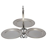 Doceira de metal prateado composta por três plateaux circulares e articuláveis unidas a alça central. 29 x 43 x 25 cm (aberto). 29 x 25 x 6 cm (fechado).Lote pertencente ao acervo de tradicional família paulistana de Américo Moreira dos Santos e Anella Mafalda Malzoni.