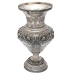 Vaso de metal prateado de forma circular. Corpo bojudo e trabalhado com flores e folhagens com fundo texturizado. 34 x 20 cm. 17 cm (bocal). Lote pertencente ao acervo de tradicional família paulistana de Américo Moreira dos Santos e Anella Mafalda Malzoni.