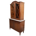 Buffet com alçada, de formato retangular em madeira lustrada, lavrado e ornamentado por almofadas, colunatas caneladas e ilhargas emolduradas. Estante com vidros ornados por frisos entrecruzados e prateiras internas. Frontão arqueado com bordas em degraus salientes. Caixa reta com tampo em mármore branco apresentando par de gavetas alinhadas e armário de duas portas. Saia inferior de mesmo estilo, apoiada em pés torneados com anelados. 200 x 115 x 45 cm. PRECISA DE RESTAURO. NO ESTADO.   Lote pertencente ao acervo de tradicional família paulistana de Américo Moreira dos Santos e Anella Mafalda Malzoni. Este lote encontra-se na residência no Ibirapuera, SP e a retirada devera ser feita a partir do endereço com a orientação da organizadora do leilão.