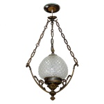 Lustre em bronze dourado e cristal, construído com globo cônico lapidado em bico de jaca, ladeado por hastes recurvas sustentadas por correntes reunidas ao topo por arremate circular. Parte inferior com bojo de sustentação ornado por pétalas e ponteira. 73 x 33 cm.  Lote pertencente ao acervo de tradicional família paulistana de Américo Moreira dos Santos e Anella Mafalda Malzoni.