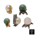 Conjunto de cinco estatuetas em estanho dourado e prateado representando tartarugas, coruja, cisne e caracol com corpos em pedra polida. Marcas do material Peltro e do fabricante MFS. 3,5 x 2 cm. Lote pertencente ao acervo de tradicional família paulistana de Américo Moreira dos Santos e Anella Mafalda Malzoni.