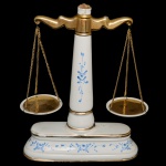Balança de cozinha de porcelana nacional. Superficie de fundo branco com decoração em azul e dourado. 32 x 23 x 8 cm. Apresenta sinais de uso (bicados). Lote pertencente ao acervo de tradicional família paulistana de Américo Moreira dos Santos e Anella Mafalda Malzoni.
