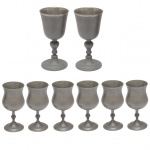 Conjunto constando de oito cálices em estanho. No fundo marca da manufatura RC X MG, sendo 2 cálices (16 cm) e 6 cálices (13 cm). Lote pertencente ao acervo de tradicional família paulistana de Américo Moreira dos Santos e Anella Mafalda Malzoni.