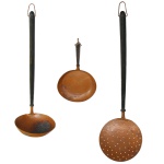 Conjunto de três peças (utensílios de cozinha) de cobre com alças de madeira. 68 x 20 cm, 60 x 18 cm e 45 x 18 cm. Lote pertencente ao acervo de tradicional família paulistana de Américo Moreira dos Santos e Anella Mafalda Malzoni.