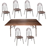 Conjunto de mesa e seis cadeiras com estrutura tubular em ferro Tampo construído com cinco tábuas retangulares em madeira lisa. Pernas retas e aneladas, rematadas ao suporte superior por hastes com volutas. Acompanham seis cadeiras com armação similar. Encostos em arcadas centralizando tabelas com hastes recurvas. Assentos bipartidos em madeira, apoiados em pernas retas reunidas aos pares por arqueados. 75 x 180 x 95 cm (mesa). 96 x 38 x 40 cm (cadeiras). SINAIS DE USO E DO TEMPO  Lote pertencente ao acervo de tradicional família paulistana de Américo Moreira dos Santos e Anella Mafalda Malzoni. Este lote encontra-se na residência no Ibirapuera, SP e a retirada devera ser feita a partir do endereço com a orientação da organizadora do leilão.