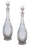 BACCARAT - Par de elegantes licoreiros em cristal francês incolor, profusamente ornamentados com lapidações geométricas. Gargalo alongado em facetas oitavadas rematado em picotados. Bordas de dimensões circulares rematadas com filetes em ouro. Tampas em formato piriforme multifacetadas. França. Final do séc. XIX. 39 cm.