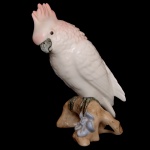 Estatueta em porcelana tcheca policromada representando cacatua de pé sobre tronco. Sob a base, marca da manufatura Royal Dux Bohemia. 21 cm. Este lote encontra-se em Belo Horizonte, MG, e só estará disponível em nossa loja a partir do dia 13 de Outubro.