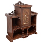 Original estante japonesa com influência Art Déco, em madeira nobre. Apresenta pequeno armário central com porta decorada por personagem e fundo floral, ornamentada por lacas a ouro e adornos embutidos, ladeado por compartimentos abertos e prateleiras. Parte superior decorada por frisos vazados com flores e folhagens. Segmento inferior realçado ao centro por par de colunatas aneladas, apoiado em montantes laterais baixos e retangulares. 85 x 86 x 32 cm. Este lote encontra-se em Belo Horizonte, MG, e só estará disponível em nossa loja a partir do dia 13 de Outubro.