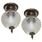 Par de lustres em bronze dourado e cristal, construído com globo cônico lapidado em bico de jaca, encimado por arremate liso em coroa. Ponteira inferior com adorno floral. 34 x 20 cm.  Lote pertencente ao acervo de tradicional família paulistana de Américo Moreira dos Santos e Anella Mafalda Malzoni. Este lote encontra-se na residência no Ibirapuera, SP e a retirada devera ser feita a partir do endereço com a orientação da organizadora do leilão.
