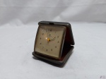 Antigo relógio de viagem, da marca Junghans, alemão. Medindo o estojo 7cm x 7cm. Necessita de revisão.